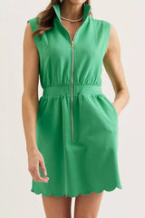 Green sleeveless zip-up mini dress with stand collar, defined waist and scalloped hem