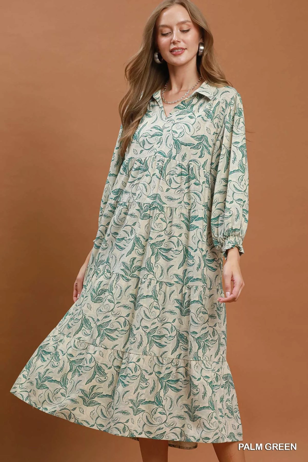 Simmer & Fay – model wearing Umgee palm green linen botanical print tiered midi dress with long sleeves